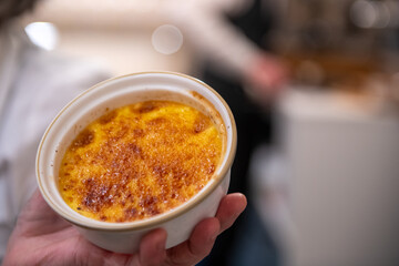Flaming creme brulee being finished with a culinary torch on a restaurant table