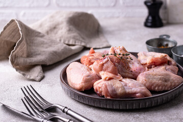 Raw chicken wings on black background.
