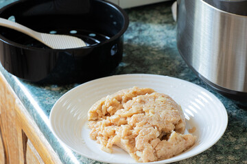 Raw minced chicken with onions in a plate in the kitchen before cooking cutlets on the table