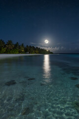 Fototapeta premium Serene Night Full Moon over Tropical Beach and Crystal Clear Ocean