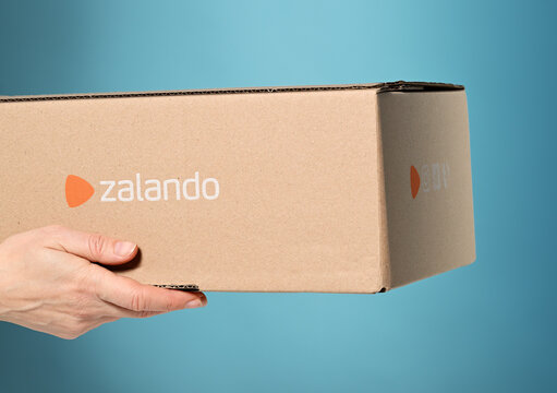 Piazza Brembana, Italy &ndash; March 6, 2025: hands with package of Zalando, e-commerce retailer of clothes and accessories