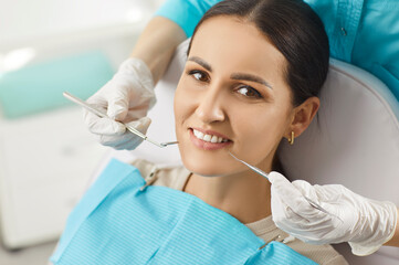 Dentist doctor conducts medical checkup of woman patient teeth and oral care during hospital visit, focusing on dental health in a professional setting with attention and precision.