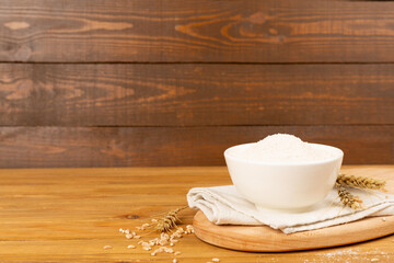 Bowl with spelt flour on wooden table