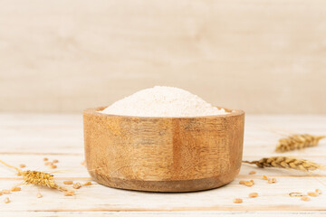 Bowl with spelt flour on wooden table