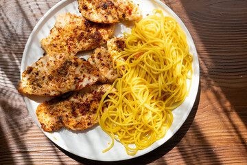 Close-up of fried chicken and spaghetti pasta Italian style restaurant presentation