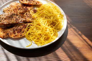 Close-up of fried chicken and spaghetti pasta Italian style restaurant presentation
