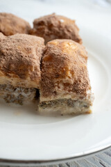 Cold baklava with cacao on a white plate	close up