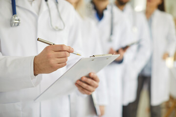 Professional doctor wearing uniform taking notes in clipboard journal, physician therapist with...