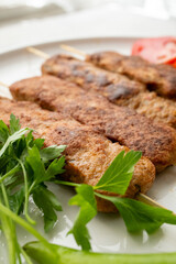 Close-up of traditional Turkish shish kebabs on oval plate