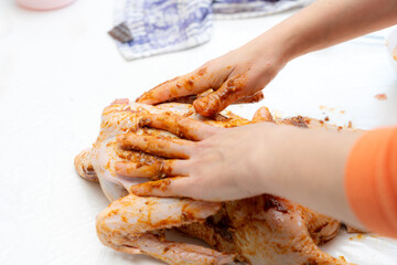 Preparing raw chicken with spices in a kitchen setting for a flavorful dish
