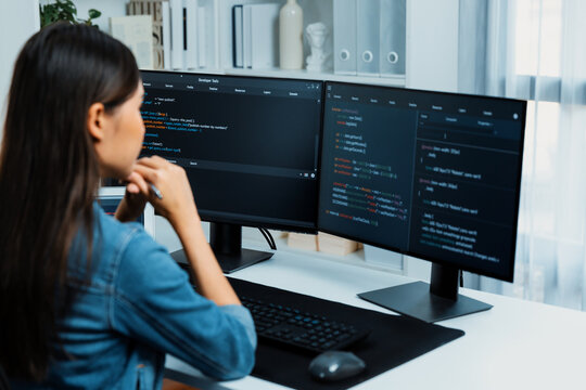 Young Asian IT developer looking online information on pc for beautiful pose with coding program data of website application, wearing jeans shirt. surround by safety analysis two screens. Stratagem.