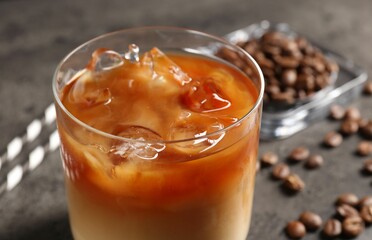 Tasty iced coffee and beans on grey table, closeup
