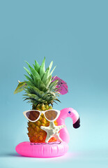 Pink inflatable flamingo and pineapple in sunglasses. Summer pool float party idea. Summer concept.