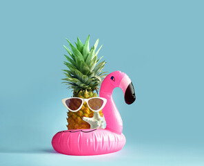 Pink inflatable flamingo and pineapple in sunglasses. Summer pool float party idea. Summer concept.