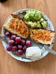 Healthy protein breakfast plate with purple grapes avocado and cream cheese