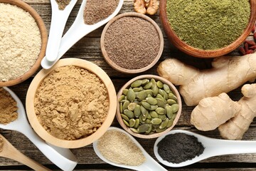 Different superfood products on wooden table, flat lay