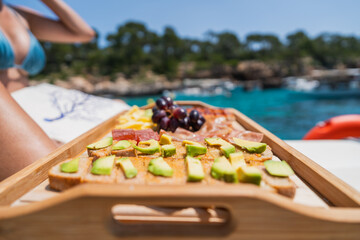 Fresh avocado toast and snacks on boat by blue sea - Close-up of healthy snacks on a boat trip....