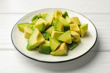 Tasty cut avocados on white wooden table, closeup