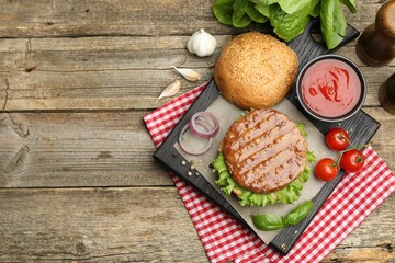 Delicious hamburger patty, bun, vegetables and spices on wooden table, flat lay. Space for text