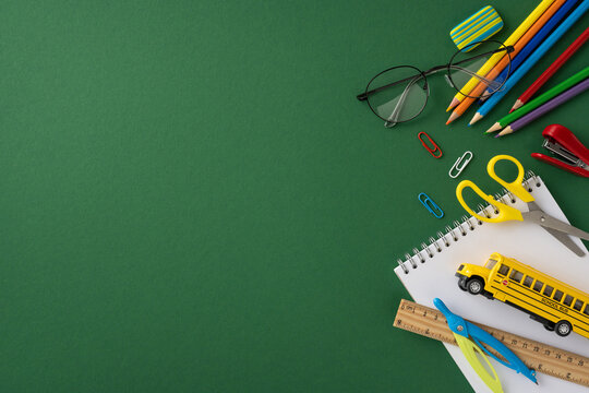 Various vibrant school supplies scattered on a green background, emphasizing creativity and education