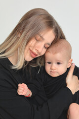 Mother and little baby son in photo studio on white background. Mother's day.