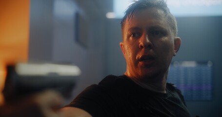Close Up of Agent in Black Tactical Clothing Breathing Heavily, Aiming the Gun and Talking to the...