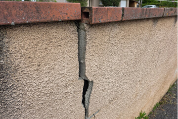 A crack in a concrete fence indicates the imminent destruction of the ceiling.