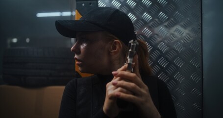 Close Up of Tired Female Secret Agent in Tactical Gear and Cap Hiding Behind Cover, Holding a...