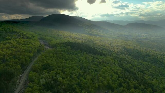 Aerial View of Lush Mountain Forest Landscape in Maine Under Dramatic Sky, drone 4K
