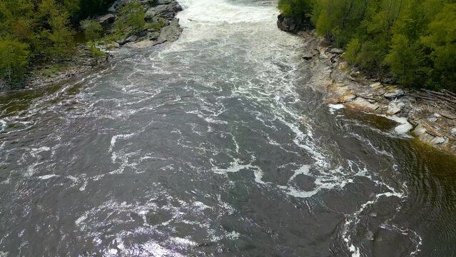Aerial View of Flowing River with Foam Patterns and Forest Shoreline in Maine