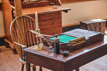 Colonial era desks and chairs with time period items 