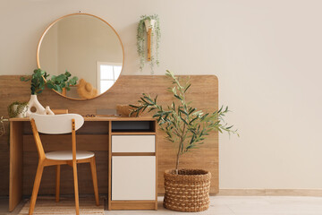 Interior of light dressing room with makeup table, mirror and plants