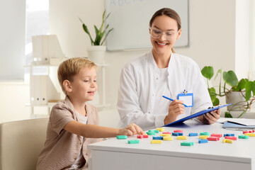 Fototapeta premium Female speech therapist working with little boy in office