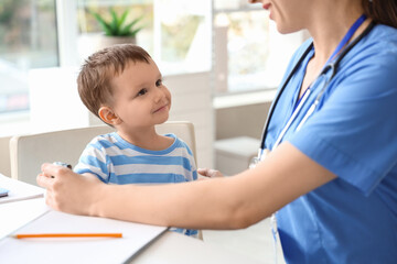 Female pediatrician checking little boy's pulse in clinic
