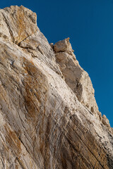 Sea cliff close-up, looking up in Cyprus. White stones cliff rocks on Mediterranean sea beach. Exotic geological sea landscape