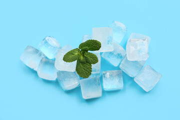Many frozen ice cubes and mint on blue background