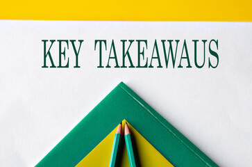 KEY TAKEAWAUS - words close-up on white sheet with folders and pencils