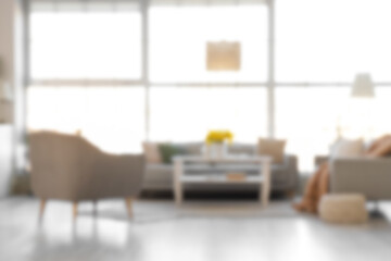 Blurred view of living room with sofas, armchair and table