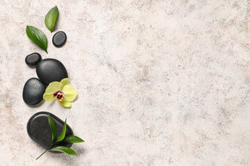 Composition with spa stones, orchid flower and plant leaves on light background