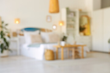 Blurred view of light bedroom with surfboard, closet and glowing lamps