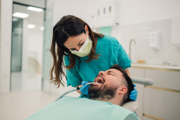 Dentist performing dental checkup on patient in clinic