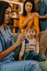 Nurse preparing medical equipment for respiratory therapy on little girl