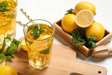 Glasses of lemon ice tea with mint and citrus fruits on white background, closeup