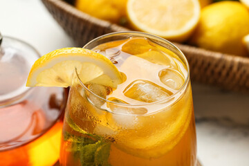 Glass of lemon ice tea with mint on white background, closeup