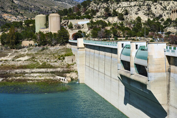 Majestic concrete dam with reservoir amidst mountainous landscape and lush trees