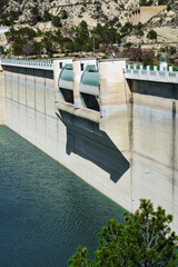 Majestic concrete dam overlooking serene reservoir in mountainous terrain