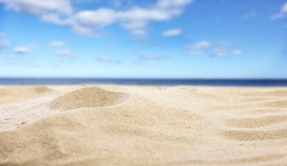 Beach Sand Close-Up with Copy Space – Summer Background for Product Placement. Sunlit beach sand...
