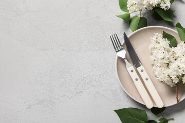 Beautiful table setting with white lilac flowers on grey background