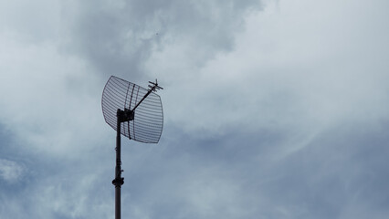Communication Tower Stands Against the Cloudy Sky in a Conflict-Affected Area, Symbolizing the Challenges of Wartime Connectivity and Information Dissemination