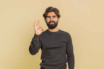 Ok. Joyful happy Lebanese man in long sleeves looking approvingly at camera showing approve...